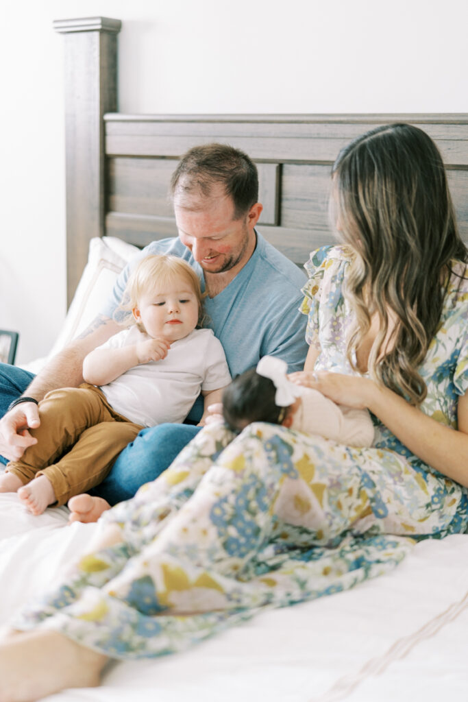 big brother admiring newborn sister during newborn session