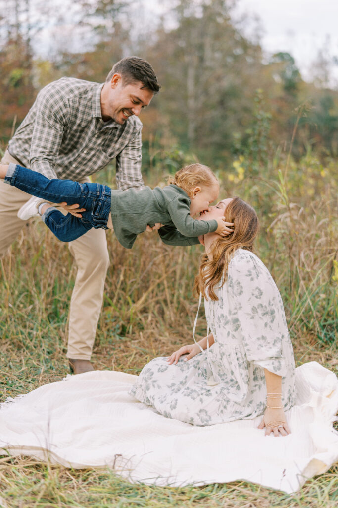 young family of three playing during family session